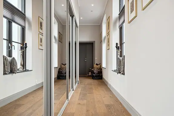 Romslig entré med stor skyvedørsgarderobe med speildører