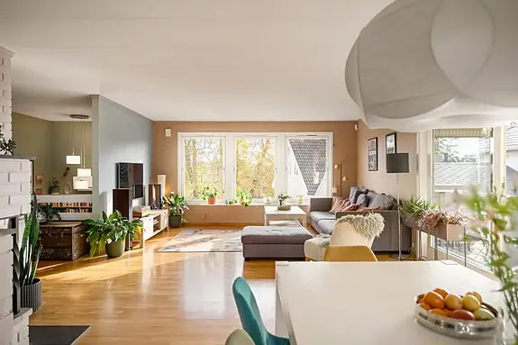 Romslig stue malt i lyse og moderne farger