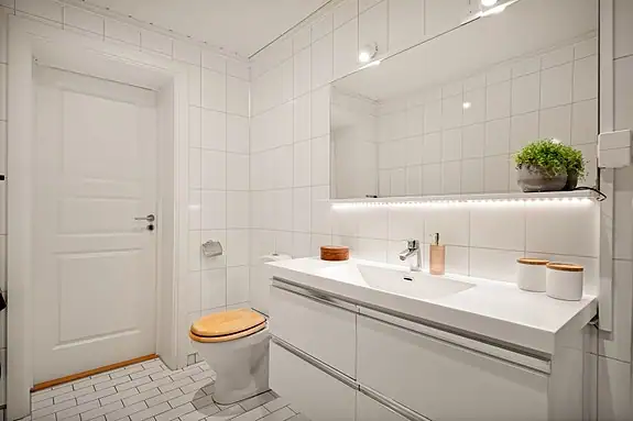 Flislagt bad med varme i gulvet og stilrene detaljer