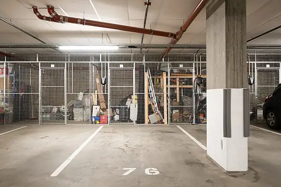 Boligen disponerer parkeringsplass og sportsbod i felles garasjekjeller