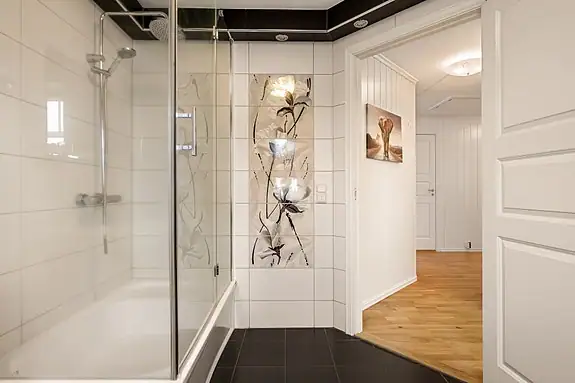 Flislagt bad med sort innredning