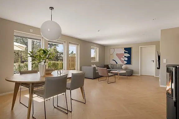 Fiskebensgulv, store vindusflater og listefrie overganger gir boligen et moderne og elegant uttrykk