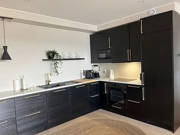 Kjøkkenet har slette fronter og laminat benkeplate
