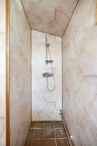Badet er utstyrt med baderomsinnredning og dusjhjørne