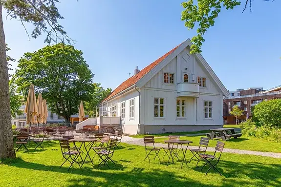 Sjarmerende nabolag med historisk hvit trehusbebyggelse og grønne omgivelser