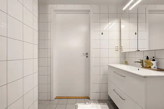 Badet inneholder servant, dusjkabinett og vegghengt wc og opplegg for vaskemaskin