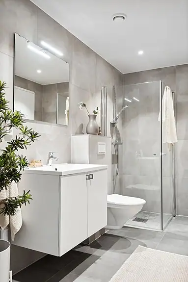 Badet er innredet med opplegg for vaskemaskin, veggmontert wc, baderomsinnredning og dusjhjørne