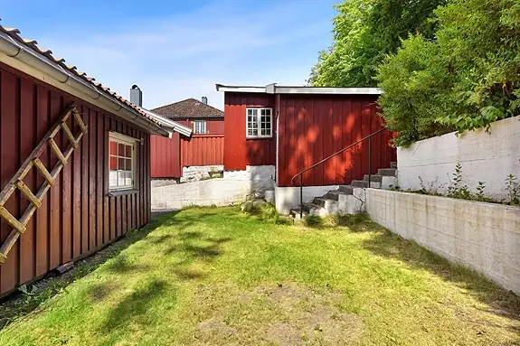 Den store, grønne fellesplenen oppleves som en naturlig forlengelse av boligen
