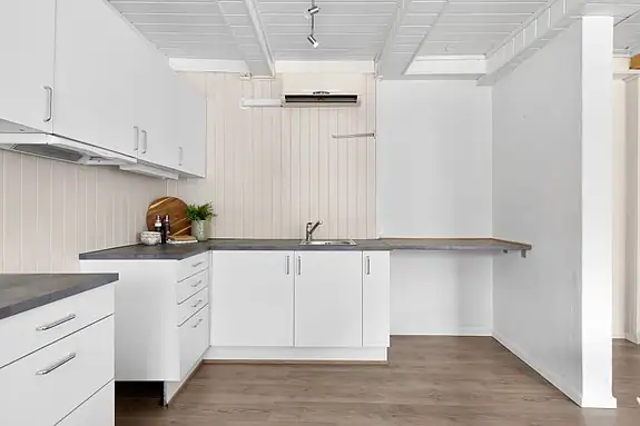 Kjøkkenet ligger i åpen forbindelse med stuen og bidrar til en sosial og luftig atmosfære