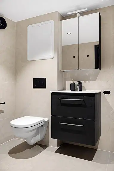 Badet er utstyrt med opplegg for vaskemaskin, baderomsinnredning og vegghengt wc