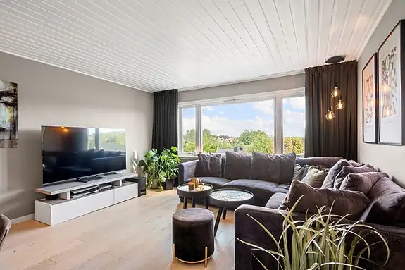 Her er det god plass til både en romslig sofagruppe, TV-møblement og et spisebord