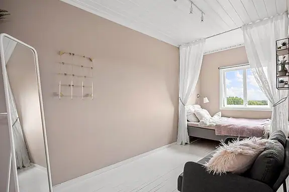 Det tredje soverommet fremstår lyst og hyggelig, med en lun og behagelig fargepalett