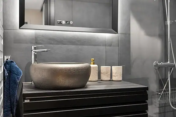 Badet er utstyrt med vegghengt wc, baderomsinnredning, opplegg for vaskemaskin og speil med integrert belysning
