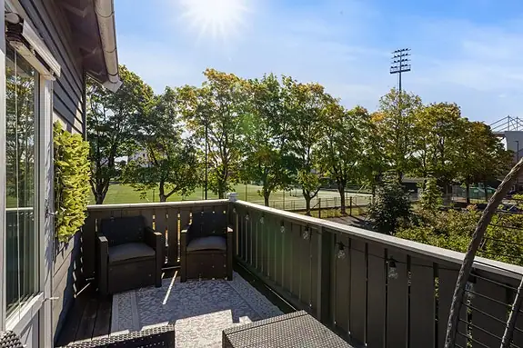 Verandaen har plass til sittegruppe og planter, med utsyn mot trær og idrettsanlegget på Melløs.