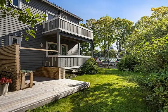 Felles hagearealer rammer inn bygningen. Leilighetens veranda ligger i andre etasje; terrassen på bakkeplan følger ikke denne andelen.