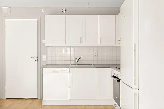 Pent, tidløst kjøkken med hvite fronter og godt med skapplass.