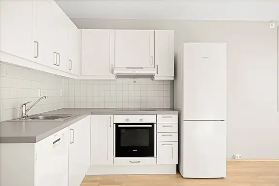 Kjøkken i lyse fargetoner som glir fint inn i oppholdsrommet