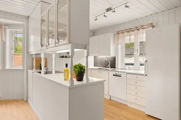 Kjøkkenet ligger i naturlig tilknytning til peisestuen og har en lys og hyggelig atmosfære