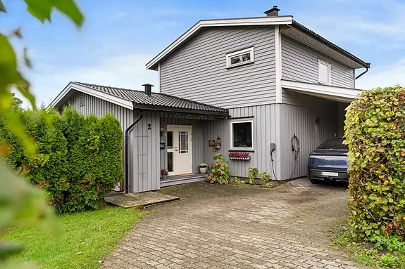 Steinlagt gårdsplass med mulighet for parkering på tomten og i carport