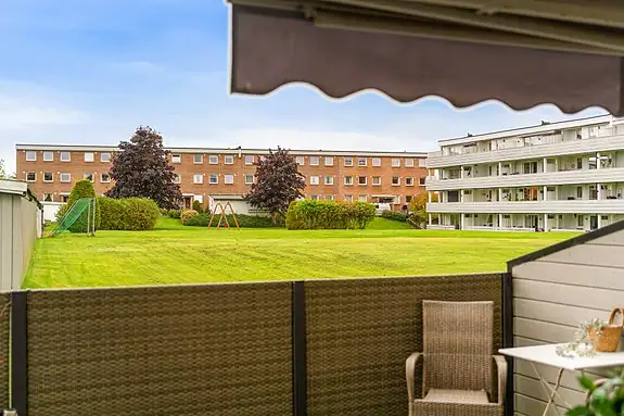 Terrassen vender ut mot et åpent og grønt fellesområde